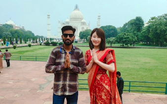 Visitors posing in front of the Taj Mahal during a tour from Delhi, Agra.