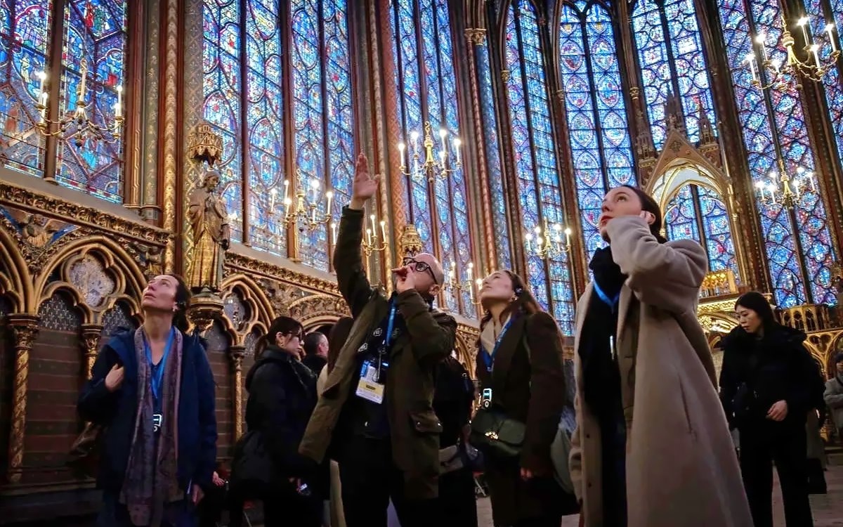 Visitors admire stained glass windows during Sainte Chapelle and Conciergerie guided tour in Paris.