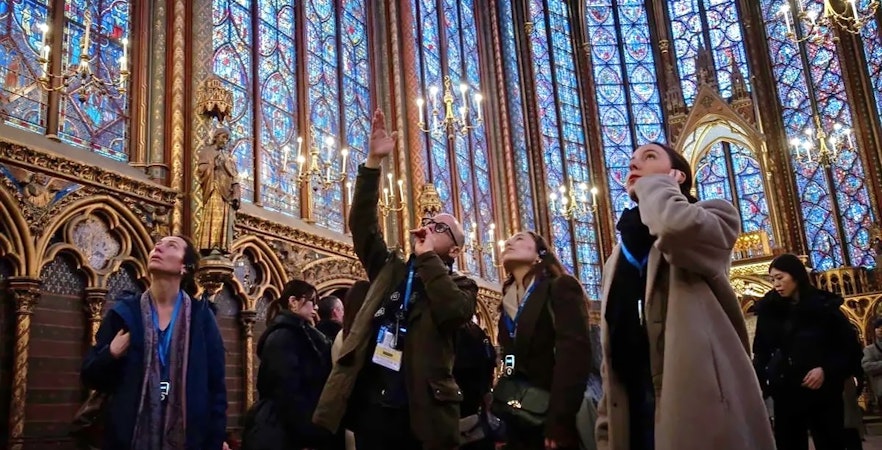 Visitors admire stained glass windows during Sainte Chapelle and Conciergerie guided tour in Paris.