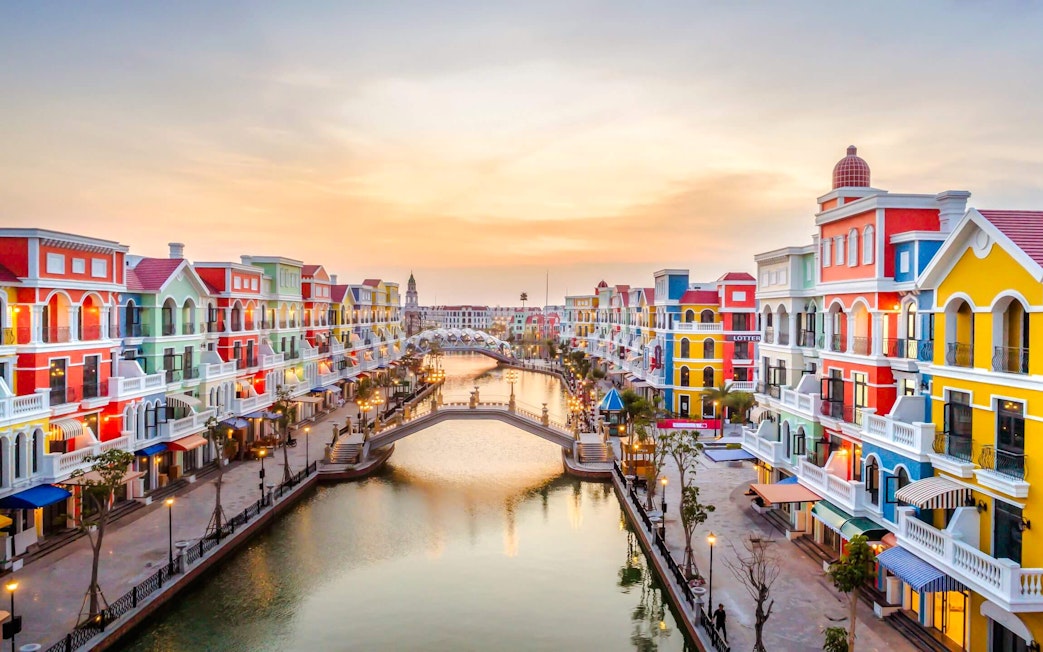 Colorful buildings along a canal at sunset in Grand World Phu Quoc.