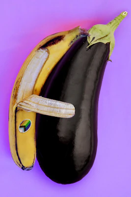 A banana and eggplant arranged to resemble an animal on a purple background.