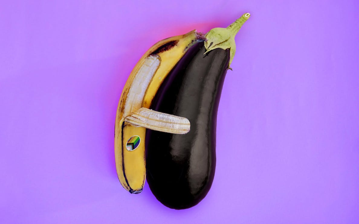 A banana and eggplant arranged to resemble an animal on a purple background.