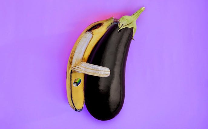 A banana and eggplant arranged to resemble an animal on a purple background.