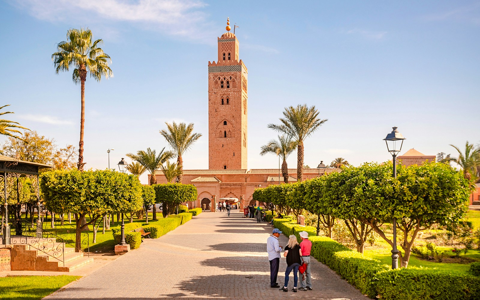 Koutoubia Mosque with gardens and visitors in Marrakech, Morocco.