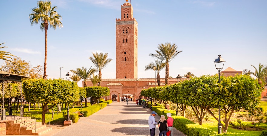 Koutoubia Mosque with gardens and visitors in Marrakech, Morocco.