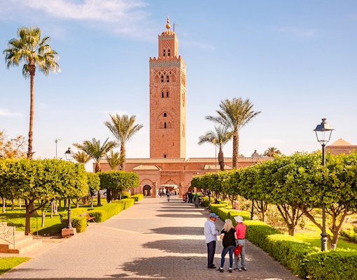 Koutoubia Mosque with gardens and visitors in Marrakech, Morocco.