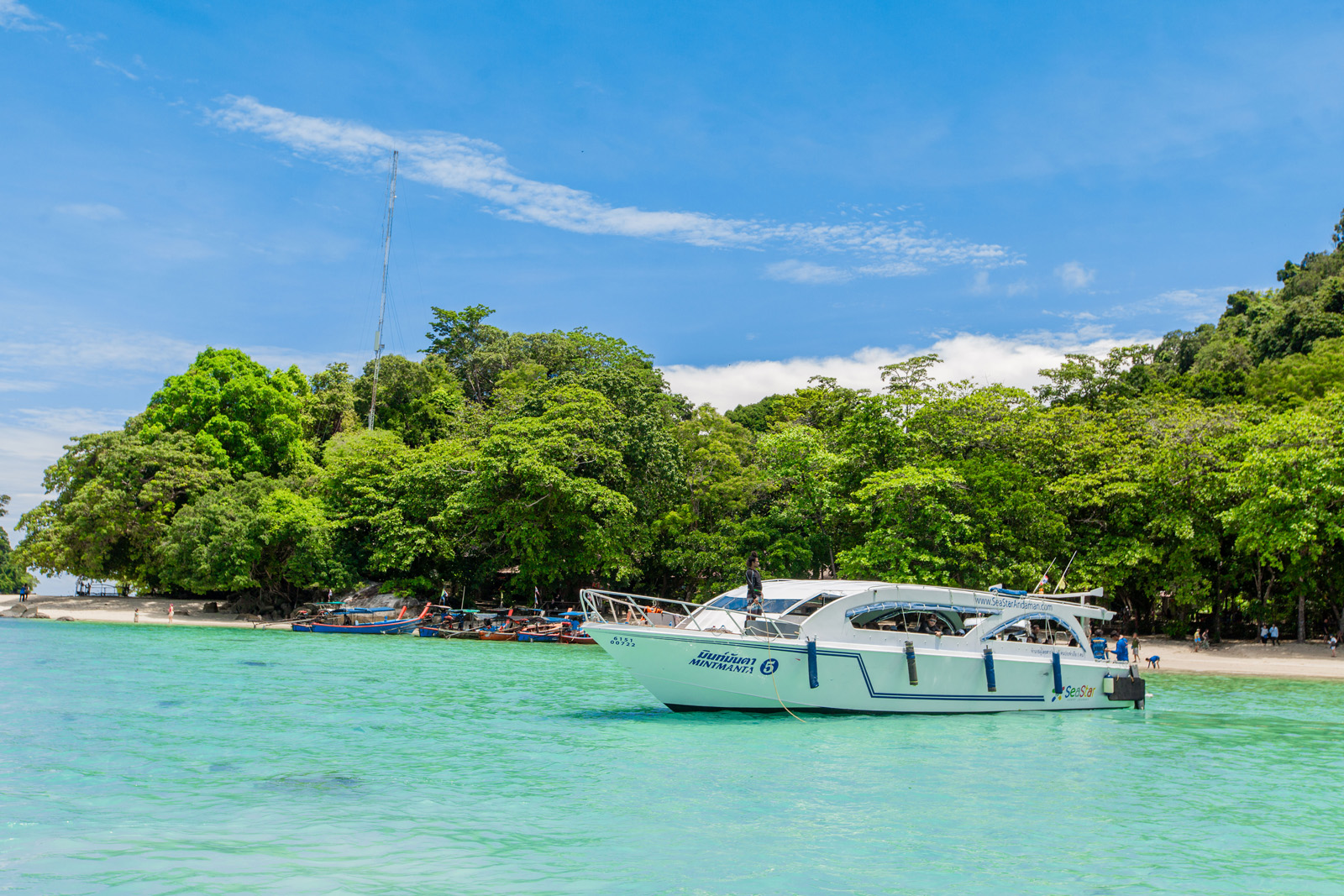 Speedboat near lush green island on Surin Islands tour, Thailand.