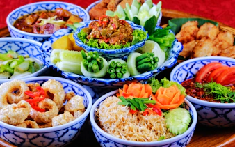 Traditional Thai dishes served in blue patterned bowls at Chiang Mai Khan Toke dinner.