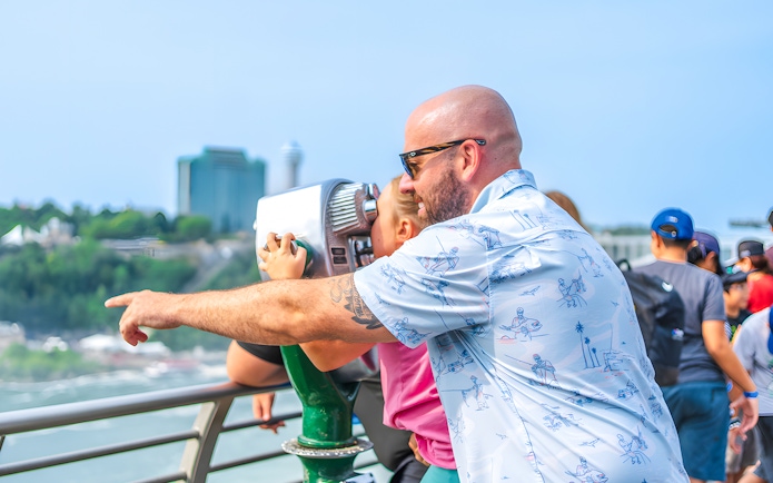 Family using binoculars at Niagara Falls observation deck.
