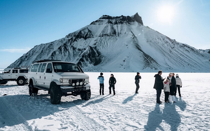 Jeep and guests on snow during Katla Ice Cave tour in Iceland.