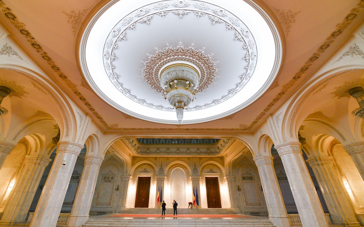 Tour group inside the grand hall of the Palace of Parliament, Bucharest, Romania.