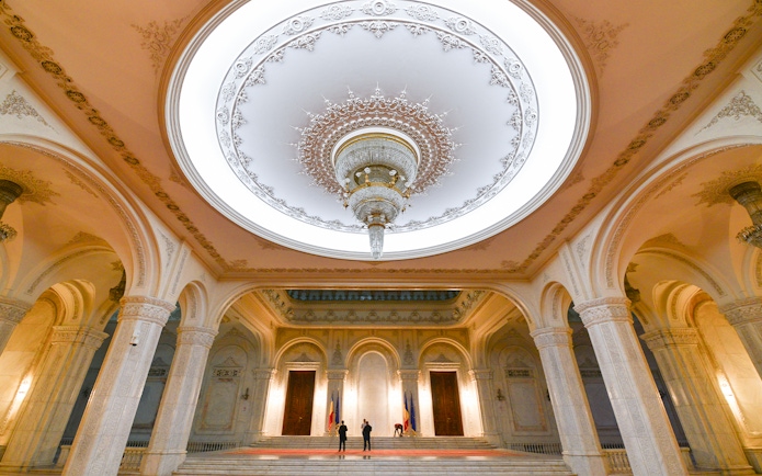 Tour group inside the grand hall of the Palace of Parliament, Bucharest, Romania.