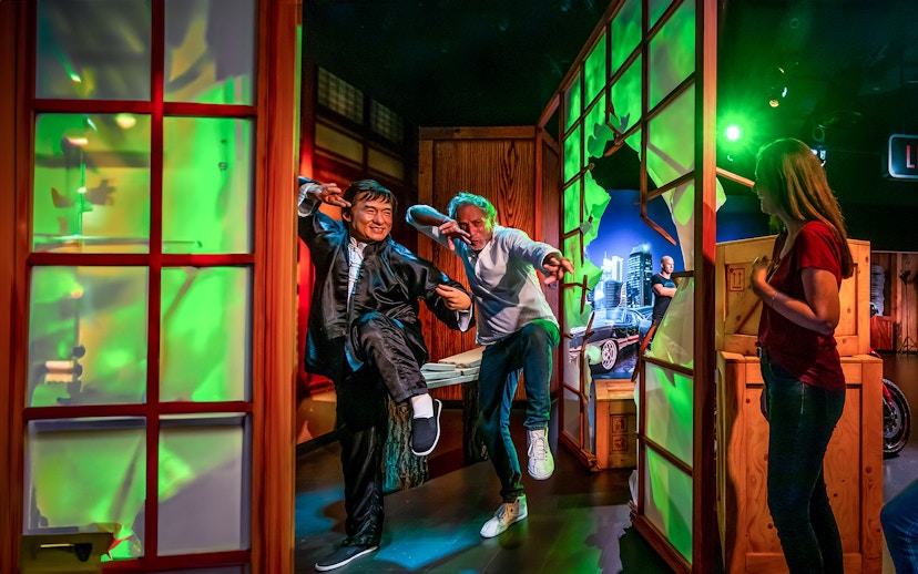 Jackie Chan wax figure with visitors posing in action at Madame Tussauds Dubai.