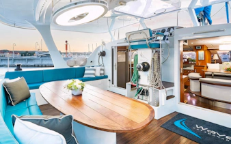 Interior of a catamaran with seating and dining area, docked in Sopot for a breakfast cruise.