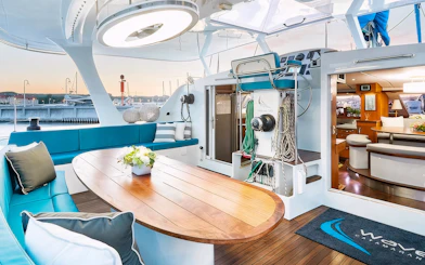Interior of a catamaran with seating and dining area, docked in Sopot for a breakfast cruise.