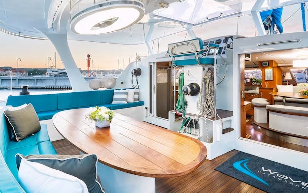 Interior of a catamaran with seating and dining area, docked in Sopot for a breakfast cruise.