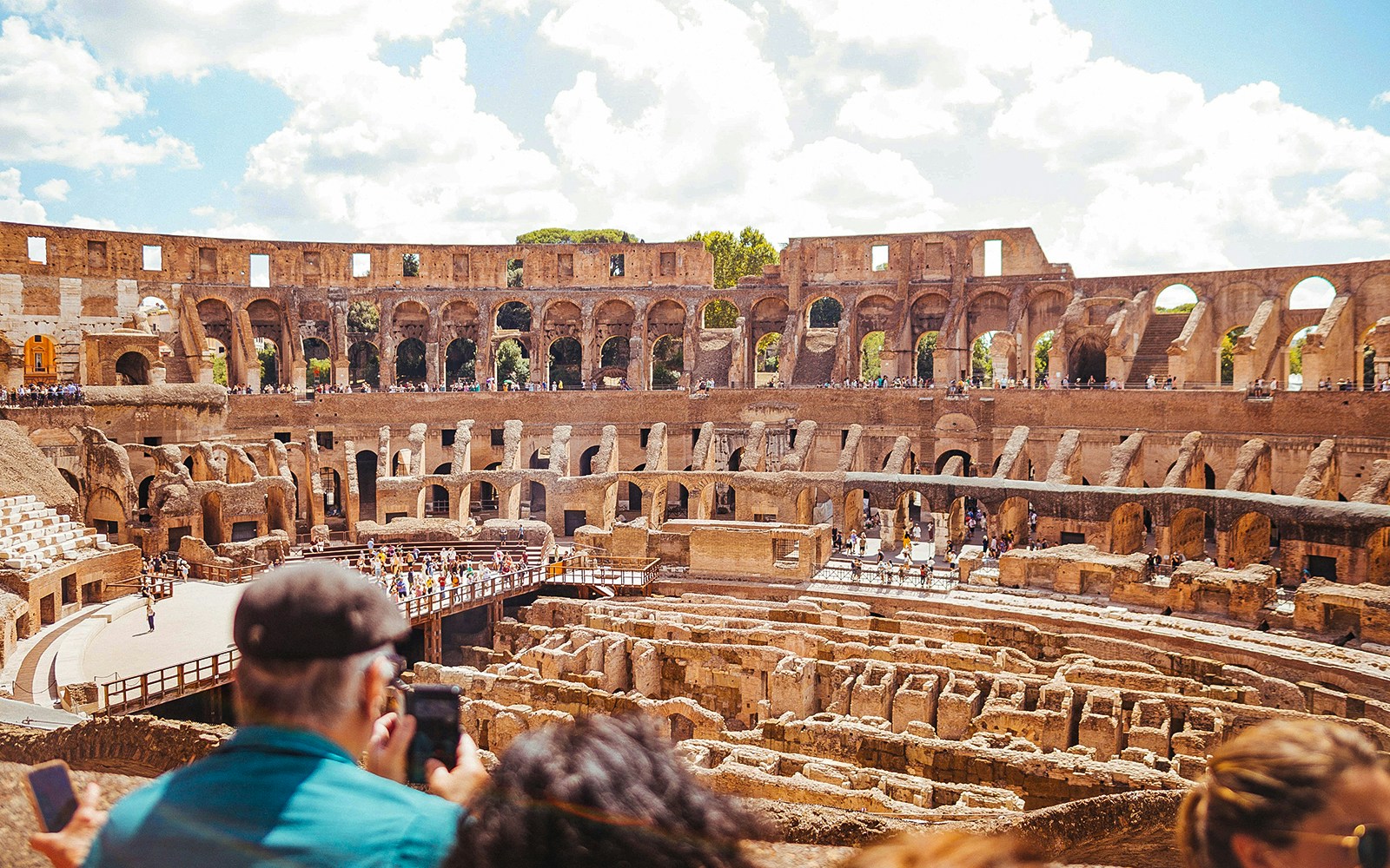 Innenansicht des Kolosseums mit Touristen auf halbprivater Tour, mit Gladiatoreneingang und Arenaboden, Rom.