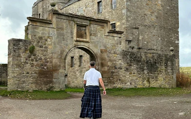 Man in kilt approaching Midhope Castle, Outlander filming location near Edinburgh.