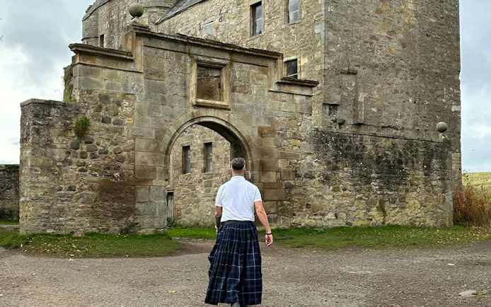 Man in kilt approaching Midhope Castle, Outlander filming location near Edinburgh.