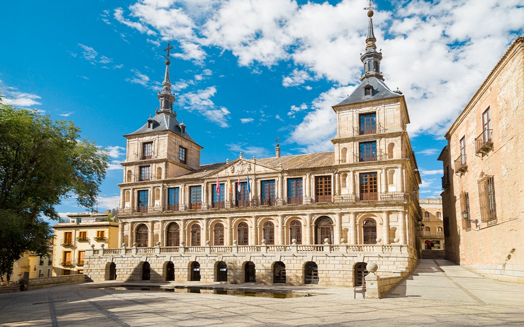 Toledo City Hall with flags and historic architecture under a blue sky.