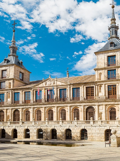 Toledo City Hall with flags and historic architecture under a blue sky.