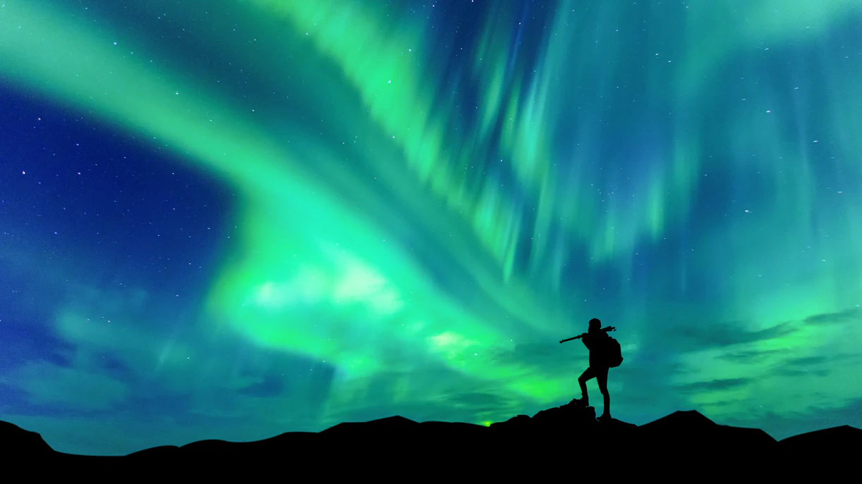 Northern lights illuminating the sky over a snowy Icelandic landscape.