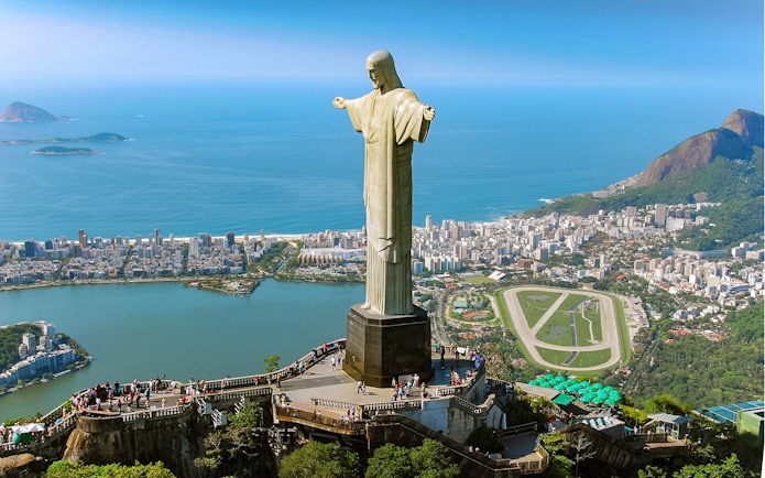 Christ the Redeemer statue overlooking Rio de Janeiro with cityscape and ocean.