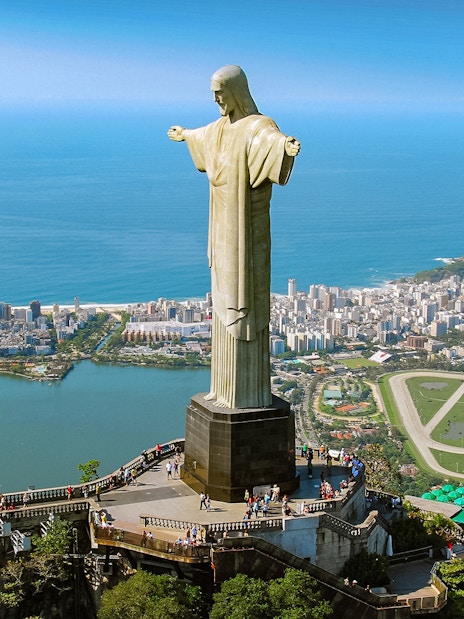 Christ the Redeemer statue overlooking Rio de Janeiro with cityscape and ocean.
