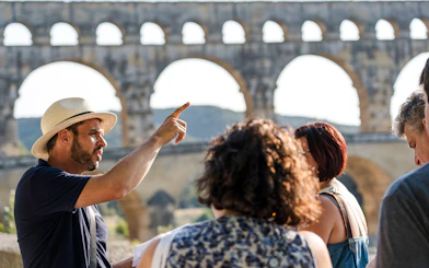 Tour guide explaining Pont du Gard to a group of visitors in France.