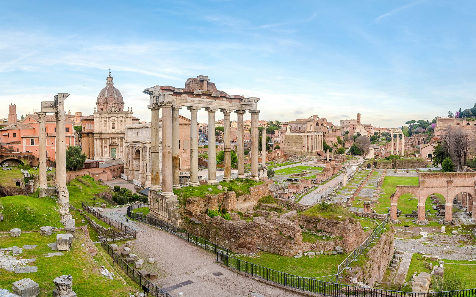 Roman Forum ruins with ancient columns and arches in Rome, Italy.