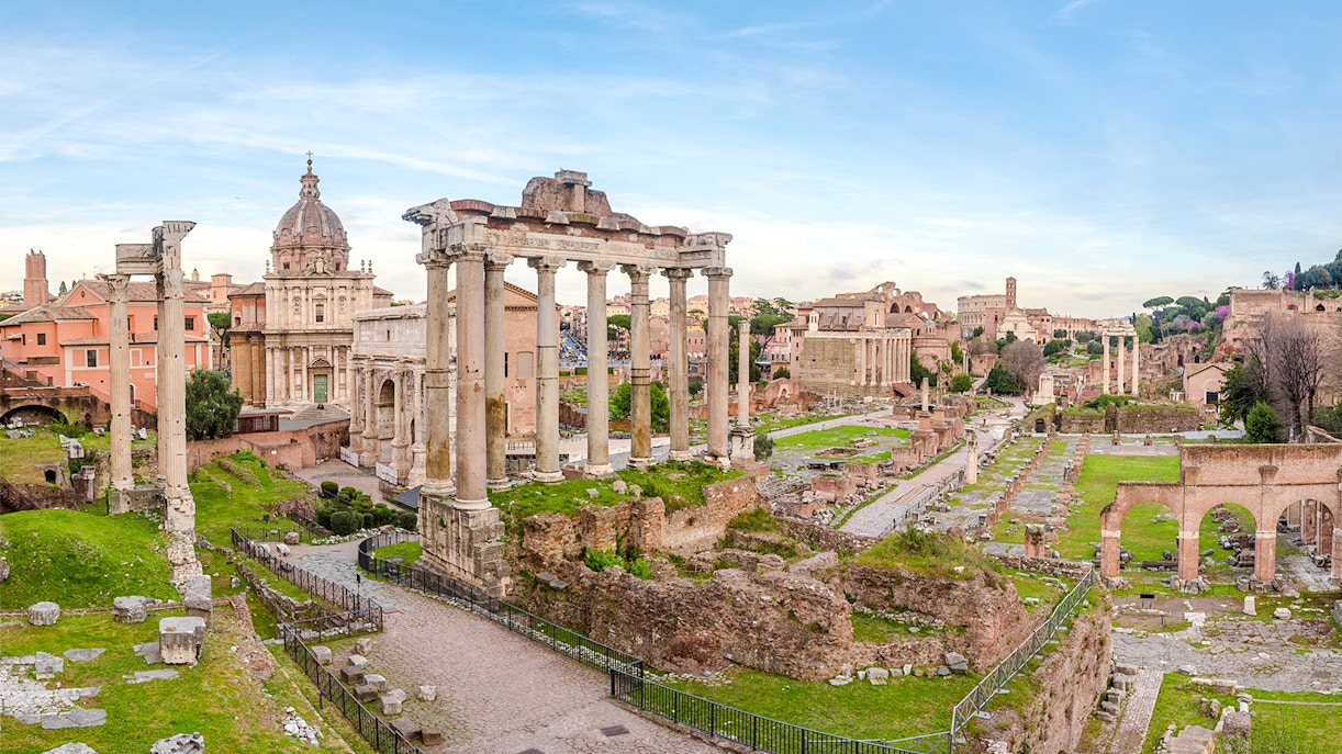 Roman Forum ruins with ancient columns and arches in Rome, Italy.