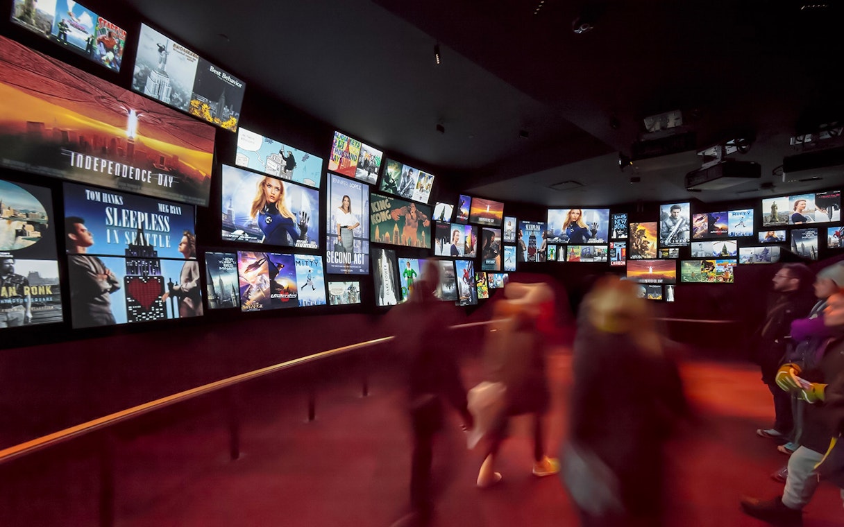 Visitors viewing movie posters at Empire State Building exhibit, New York City.