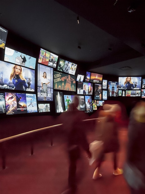 Visitors viewing movie posters at Empire State Building exhibit, New York City.