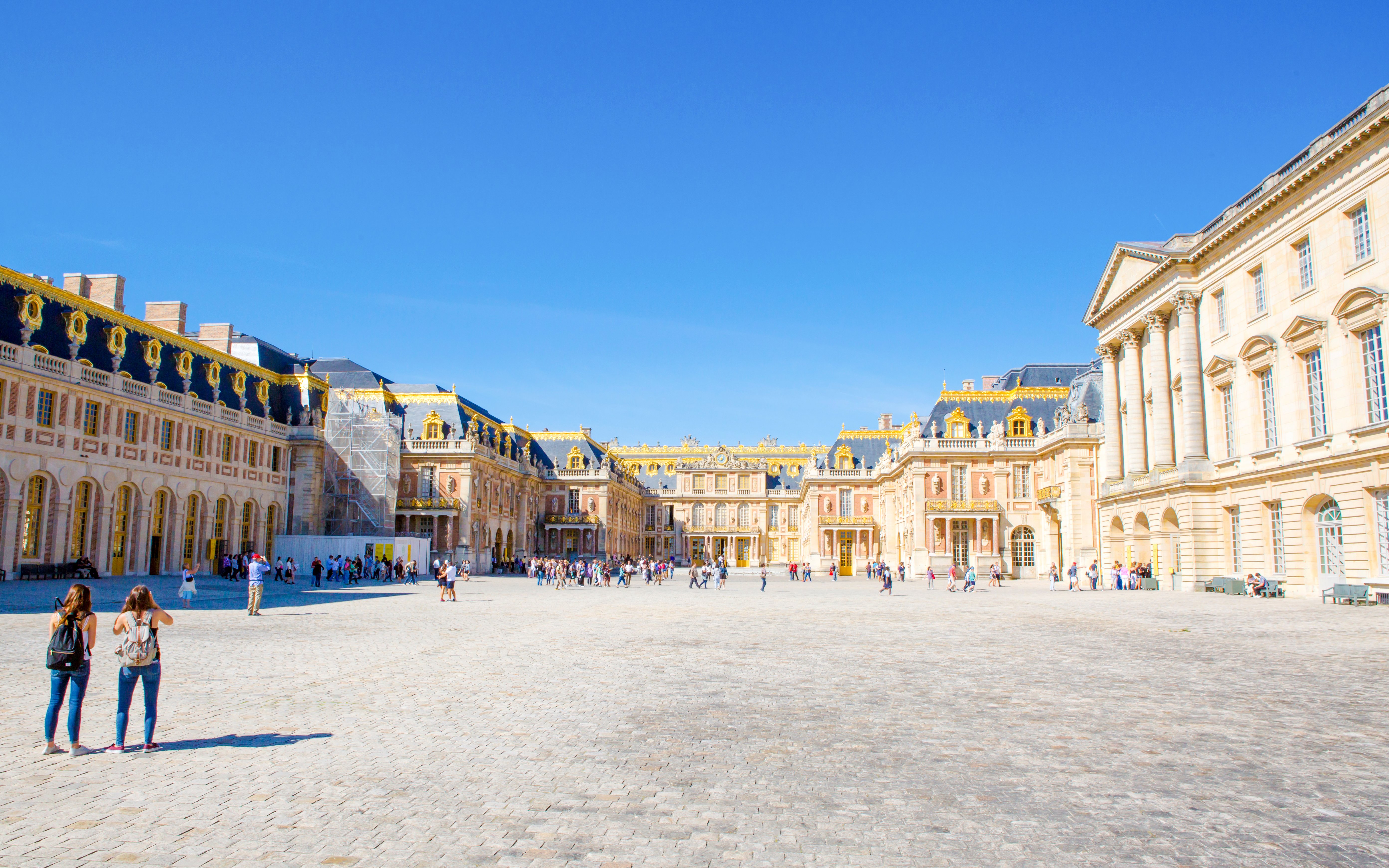 Courtyard of Place d’Armes Versailles with tourists exploring the historic architecture.
