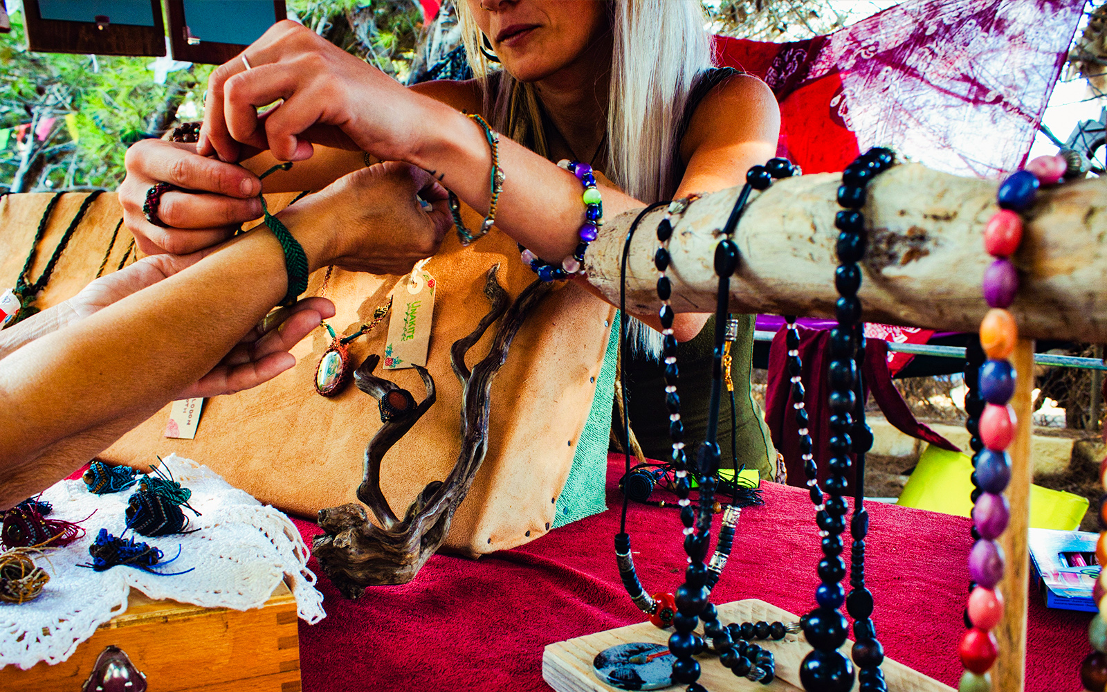 Person trying on bracelet at beads jewellery shop display.