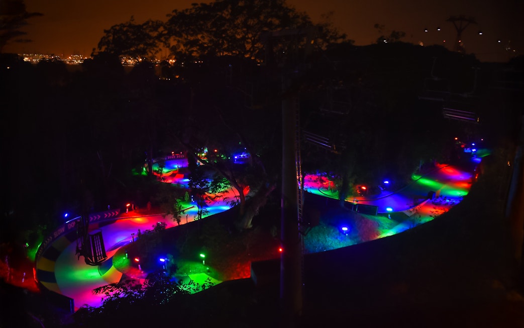 Night luge track illuminated with colorful lights in Singapore.