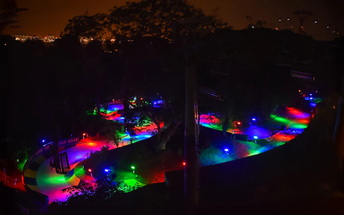 Night luge track illuminated with colorful lights in Singapore.