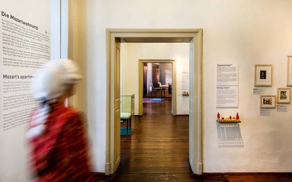 Guests walking through Mozarthaus Vienna exhibit rooms.