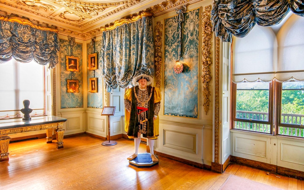 Warwick Castle interior with historical figure statue and ornate decor.