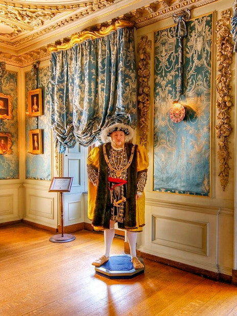 Warwick Castle interior with historical figure statue and ornate decor.