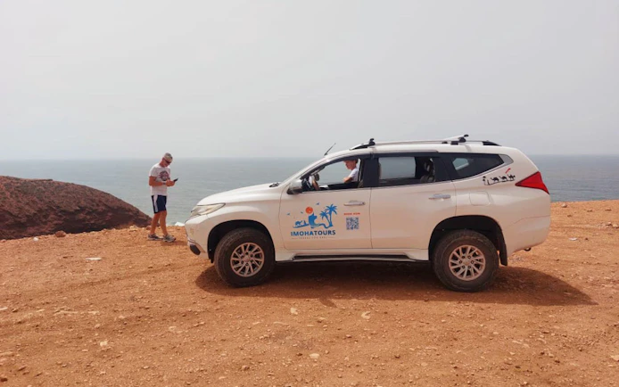 4x4 vehicle on Agadir desert cliff with ocean view, part of Sahara adventure tour.