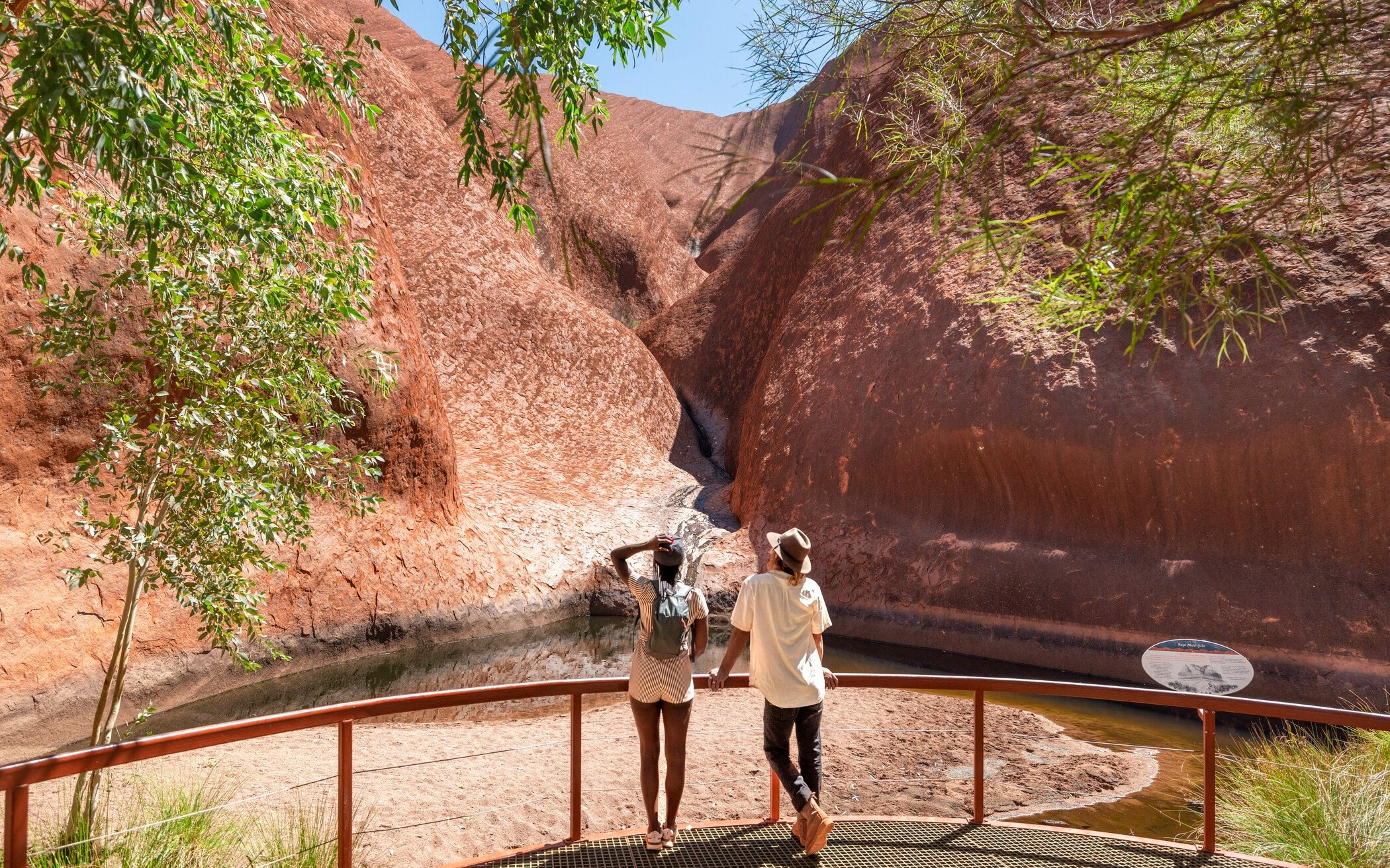 Woman standing in front of Kata Tjuta rock formations at sunset, Uluru-Kata Tjuta National Park.
