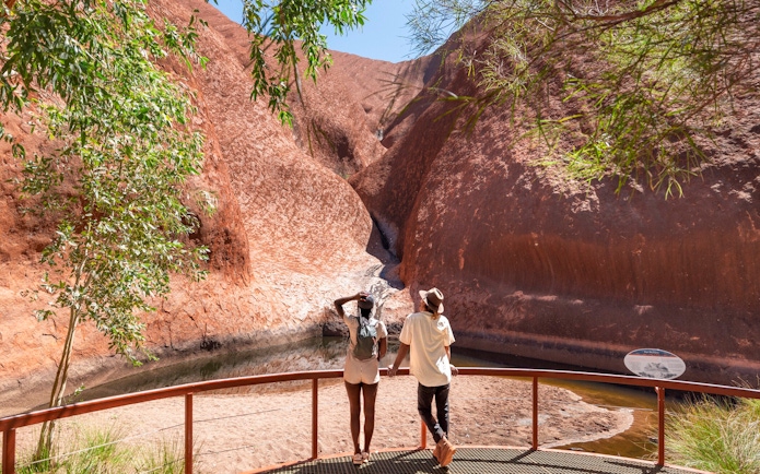 Visitors viewing Uluru rock formations on the Outback camping adventure.