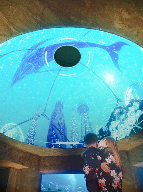 Mother and child viewing underwater exhibit at The Lost World Aquarium.