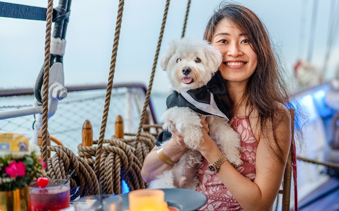 Woman holding a dog on the Royal Albatross sunset dinner cruise.