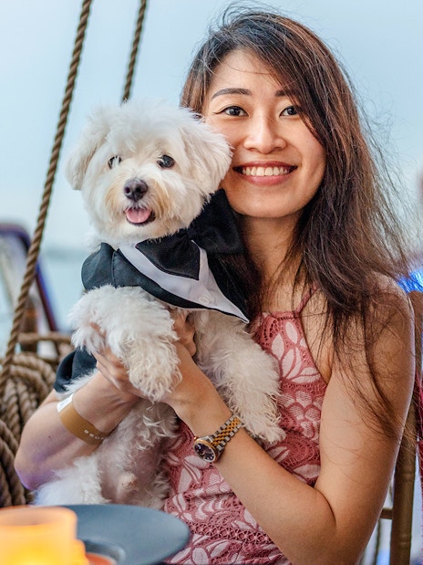 Woman holding a dog on the Royal Albatross sunset dinner cruise.
