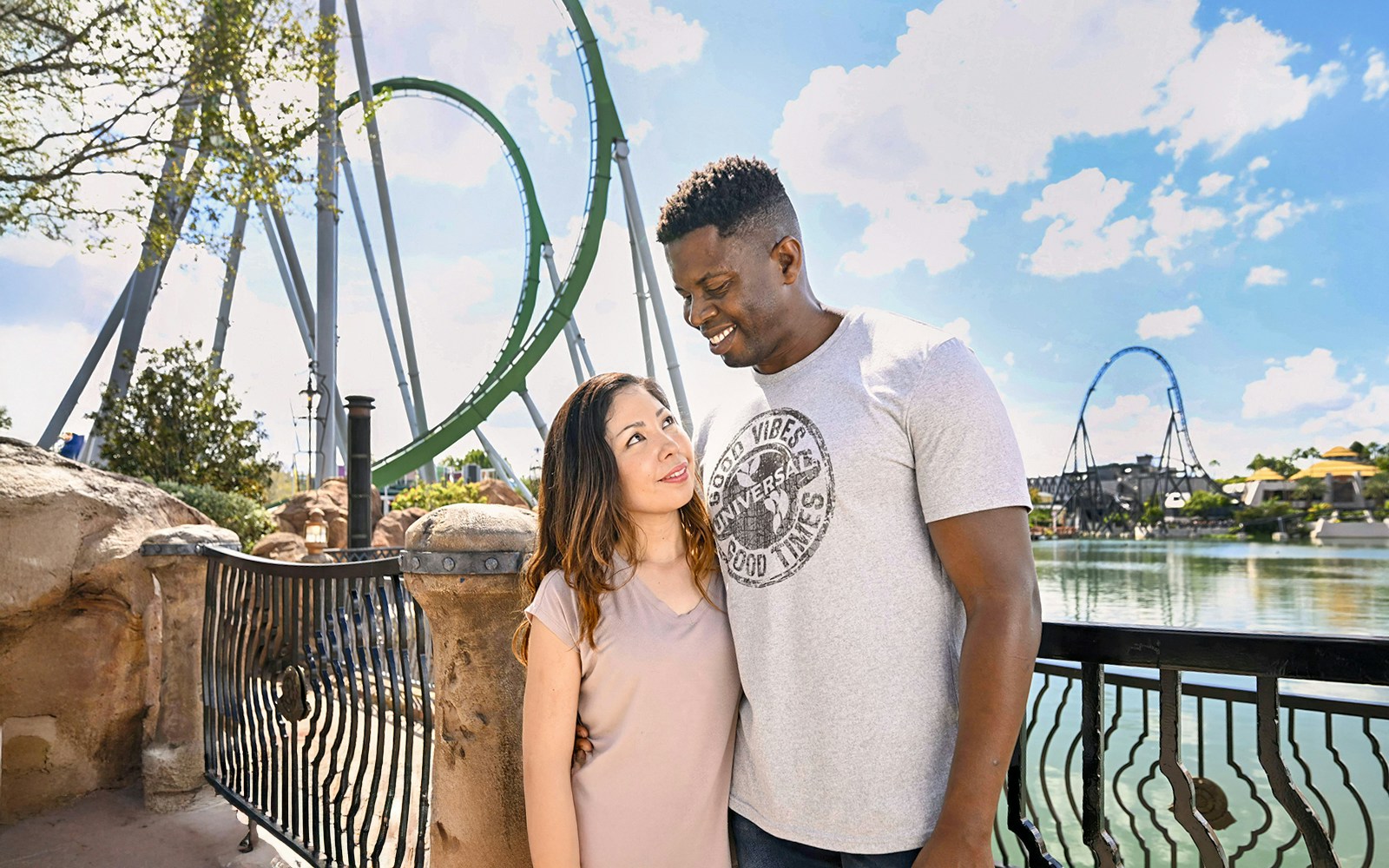 Couple posing with rollercoaster in background at Universal Studios Orlando.
