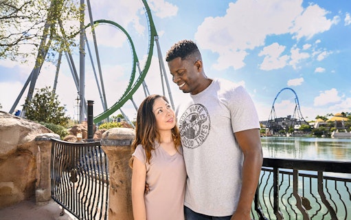 Couple posing with rollercoaster in background at Universal Studios Orlando.