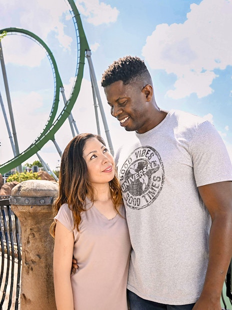 Couple posing with rollercoaster in background at Universal Studios Orlando.
