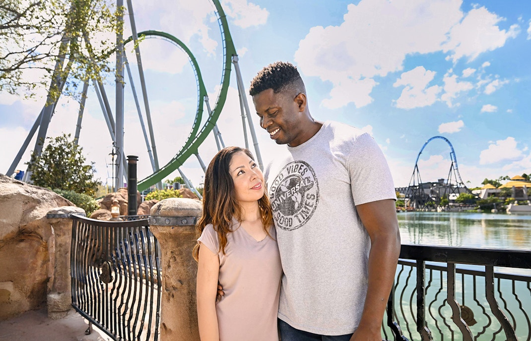 Couple posing with rollercoaster in background at Universal Studios Orlando.